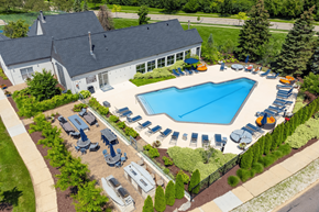 Ann Arbor apartment for rent - A large swimming pool surrounded by sun loungers and trees.