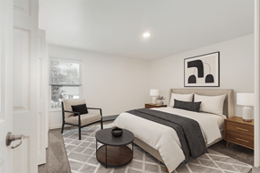 Holland apartment for rent - A bedroom with a large bed, a chair, and a table.