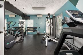 East Lansing apartment for rent - A gym with a treadmill, elliptical machines, and weights.
