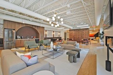 Troy apartment for rent - A modern living room with a grey sofa and a glass coffee table.