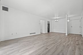 Southfield apartment for rent - A spacious room with wood flooring and white walls.
