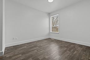 Allen Park apartment for rent - a bedroom with white walls and wood flooring and a window