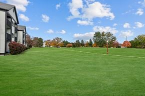 Lansing apartment for rent - A red flag is in the distance on a grassy field.