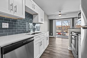 Troy apartment for rent - a kitchen with white cabinets and stainless steel appliances and a window at Sunnymede Apartments - Troy, MI, Troy, 48084