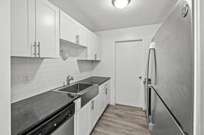 Southfield apartment for rent - A kitchen with white cabinets and a black counter top.