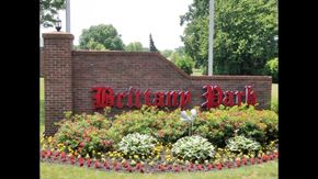 Harrison Twp apartment for rent - a brick wall with a red sign and flowers in front of it