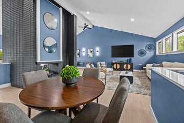 Flint apartment for rent - a living room with blue walls and a table with chairs