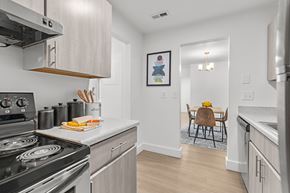 Westland apartment for rent - A modern kitchen with a stove, oven, and a dining table set for two.