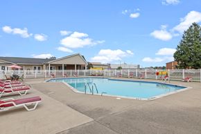 Roseville townhouse for rent - a swimming pool with chaise lounge chairs and a building in the background