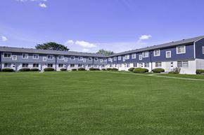 Canton townhouse for rent - A large grassy area in front of a building with a tree.