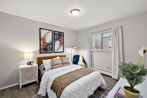 Ann Arbor townhouse for rent - A bedroom with a large bed and two framed pictures on the wall.
