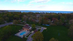 Harrison Twp apartment for rent - an aerial view of a house with a pool and a lake in the background