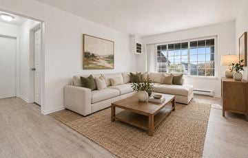 Roseville townhouse for rent - A living room with a white couch, a brown coffee table, and a painting on the wall.