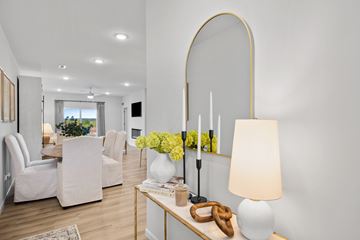 Kalamazoo townhouse for rent - A modern living room with a white sofa set, a coffee table with a lamp, and a vase of yellow flowers.