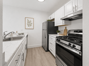 Grand Rapids apartment for rent - A kitchen with a black stove top oven and white cabinets.
