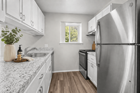 Waterford apartment for rent - A kitchen with white cabinets and a marble countertop.