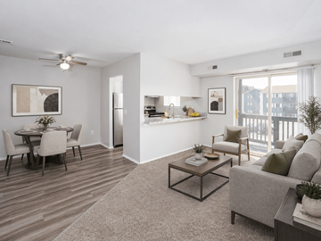 Waterford apartment for rent - A living room with a grey couch, a coffee table, and a dining table with chairs.