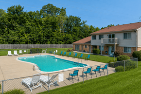 West Bloomfield apartment for rent - A pool with chairs around it and a house in the background.