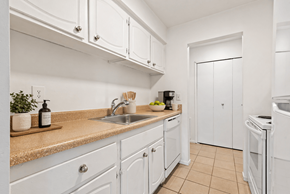 West Bloomfield apartment for rent - A kitchen with white cabinets and a beige countertop.