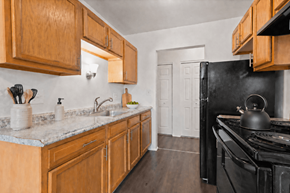 Warren apartment for rent - A kitchen with wooden cabinets and a black stove.