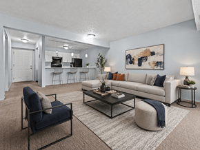 Lansing apartment for rent - A living room with a white couch, a blue chair, and a coffee table.