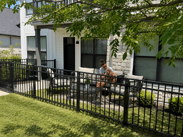 Grand Rapids apartment for rent - A woman is sitting on a bench with her dog in front of a white house.