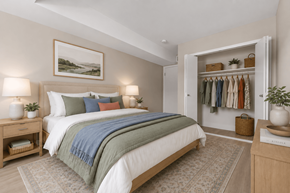 Troy apartment for rent - A bedroom with a large bed and a wardrobe with clothes hanging on it.
