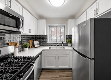 Oak Park townhouse for rent - A modern kitchen with a black stove top oven and a black refrigerator.