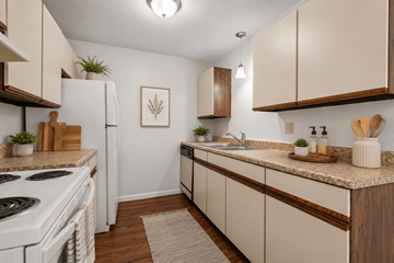 Flint apartment for rent - A kitchen with white appliances and wooden cabinets.