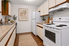 Flint apartment for rent - A kitchen with a white stove top oven and a white refrigerator.