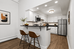 Livonia apartment for rent - A kitchen with white cabinets and a black countertop.