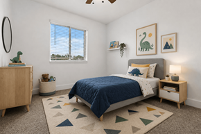 Auburn Hills apartment for rent - A bedroom with a blue bedspread and a rug with triangles on it.