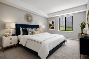 Northville apartment for rent - A bedroom with a large bed and a mirror on the wall.