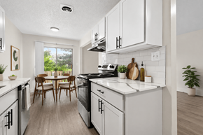 Sterling Heights townhouse for rent - A modern kitchen with white cabinets and a wooden table.