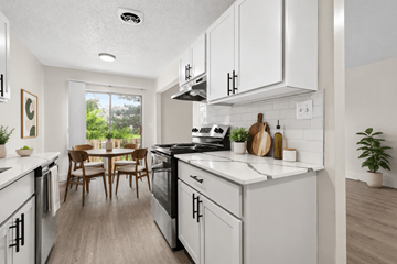 Sterling Heights townhouse for rent - A modern kitchen with white cabinets and a wooden table.