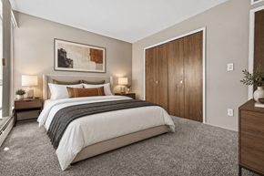 Roseville townhouse for rent - A bedroom with a large bed and a painting above it.