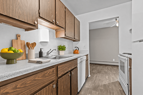 Roseville townhouse for rent - A kitchen with wooden cabinets and white appliances.