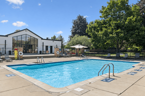 Rochester Hills apartment for rent - A large outdoor swimming pool with a building in the background.