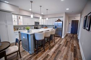 Royal Oak apartment for rent - a kitchen with a large island with chairs and a refrigerator