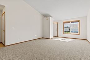 Saginaw townhouse for rent - a spacious living room with carpet and a window
