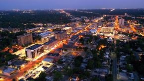 Royal Oak apartment for rent - A cityscape at night with buildings and streets illuminated.