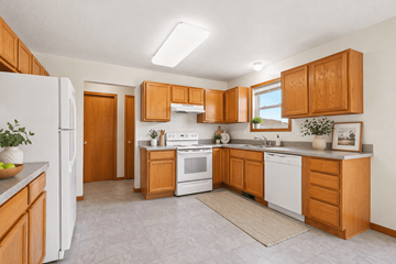 Freeland triplex for rent - A kitchen with wooden cabinets and white appliances.