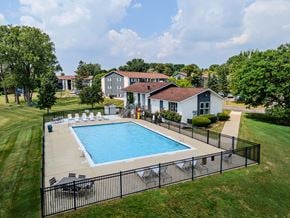 Waterford apartment for rent - A pool surrounded by a black fence with a house in the background.