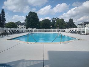 Westland apartment for rent - a swimming pool with chairs and a fence around it
