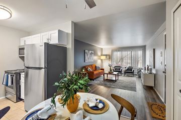 Wixom apartment for rent - a kitchen and living room with a refrigerator and a table