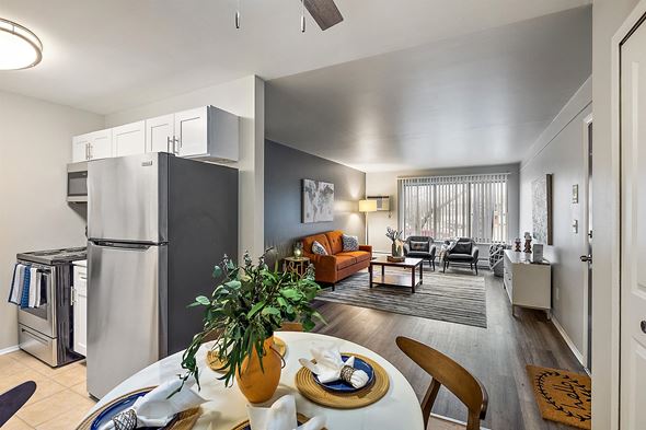Wixom apartment for rent - a kitchen and living room with a refrigerator and a table at Town & Country Apartments - Wixom, MI, Michigan