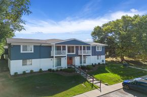 Wixom apartment for rent - a blue and white house with a yard and trees at Town & Country Apartments - Wixom, MI, Wixom, Michigan