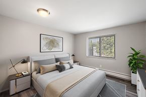 Wixom apartment for rent - a bedroom with a large bed and a window at Town & Country Apartments - Wixom, MI, Wixom, 48393