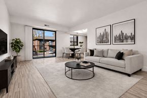 Detroit apartment for rent - A living room with a grey couch, a coffee table, and two framed pictures on the wall.