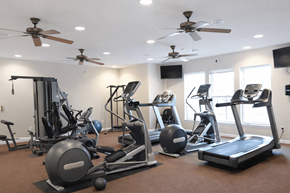 Petoskey apartment for rent - A spacious gym with a variety of equipment including treadmills, stationary bikes, and weight machines.